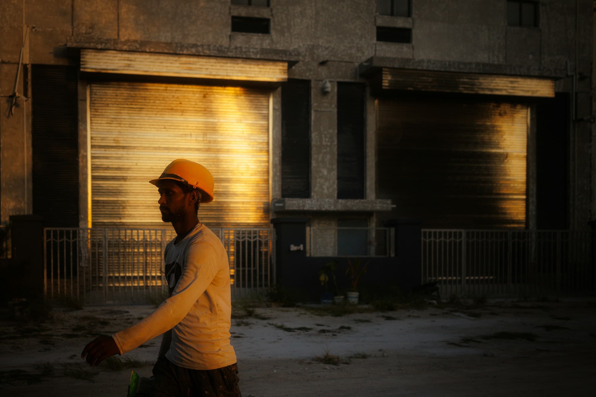 A worker in a hard hat passing an industrial building at dusk: the regulated-industry context of a statutory prosecution